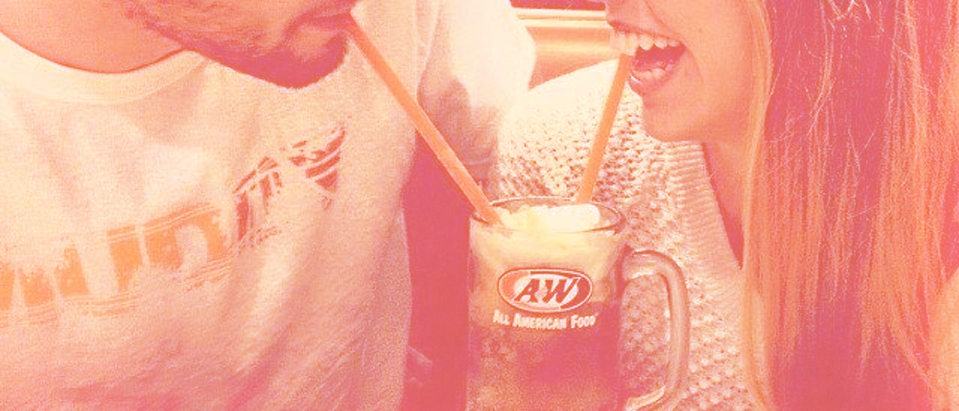 Boy and girl drinking from a Root Beer Float with two straws
